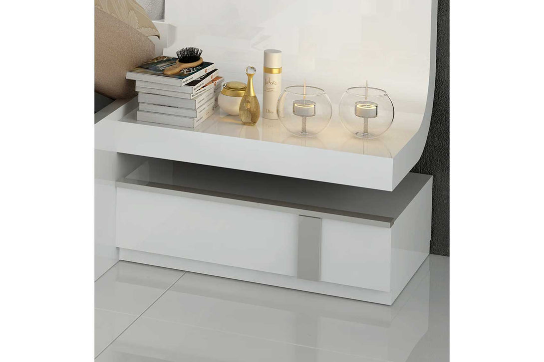 White nightstand with decorative items on a white background