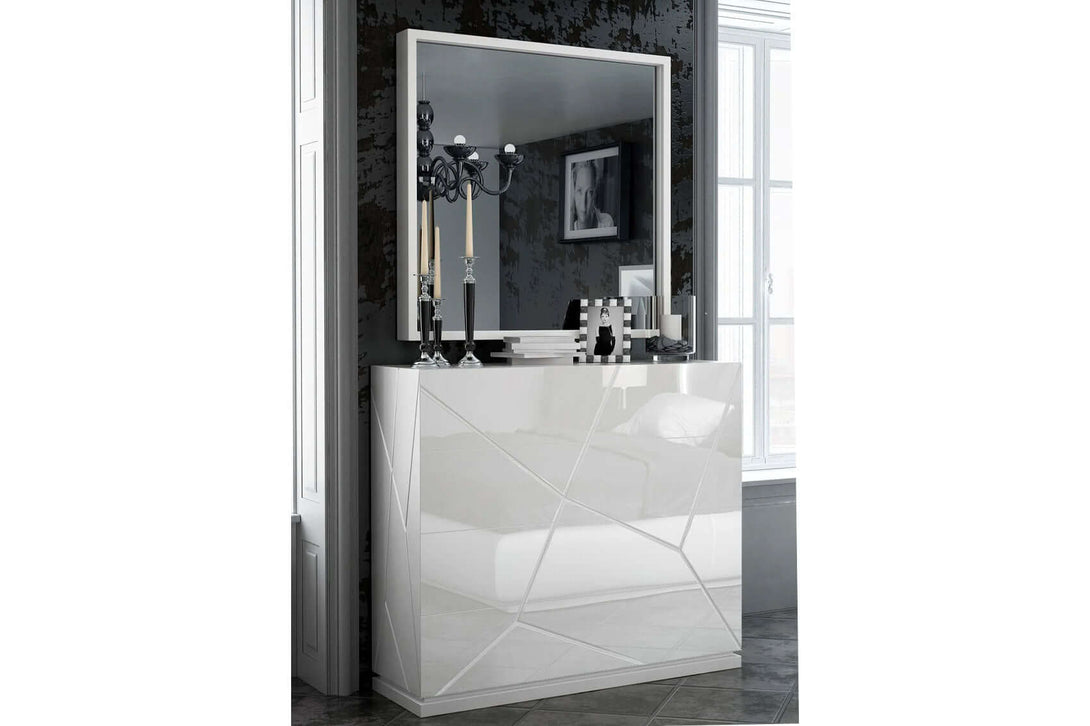 White dresser with geometric design in a room with a mirror reflecting decor elements.