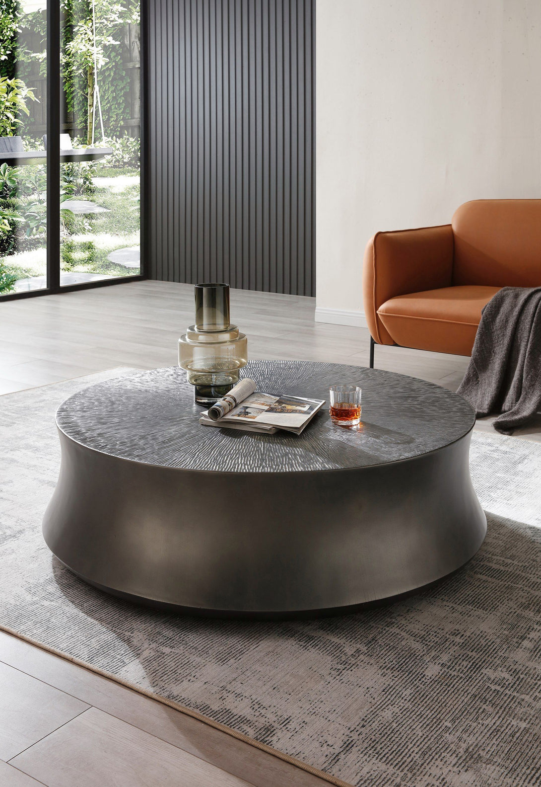 Round coffee table with a glass of wine and a magazine in a modern living room.