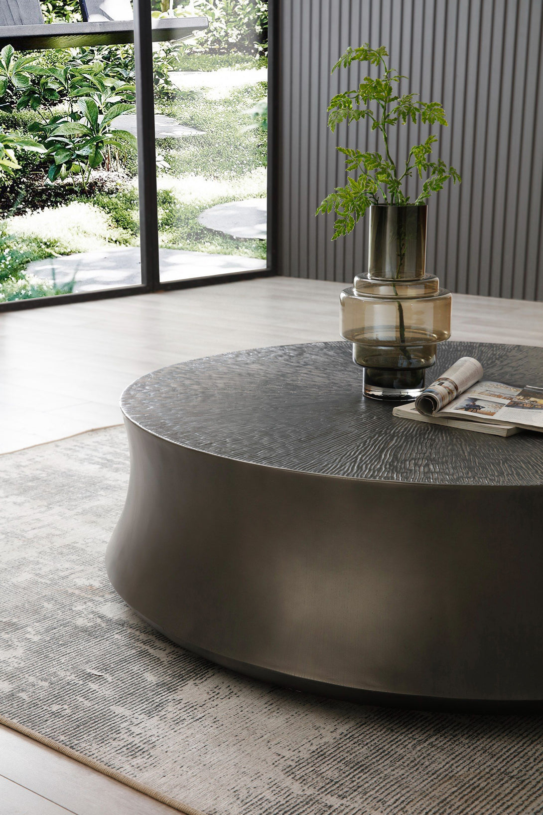 Round coffee table with a plant and books in a modern living room.